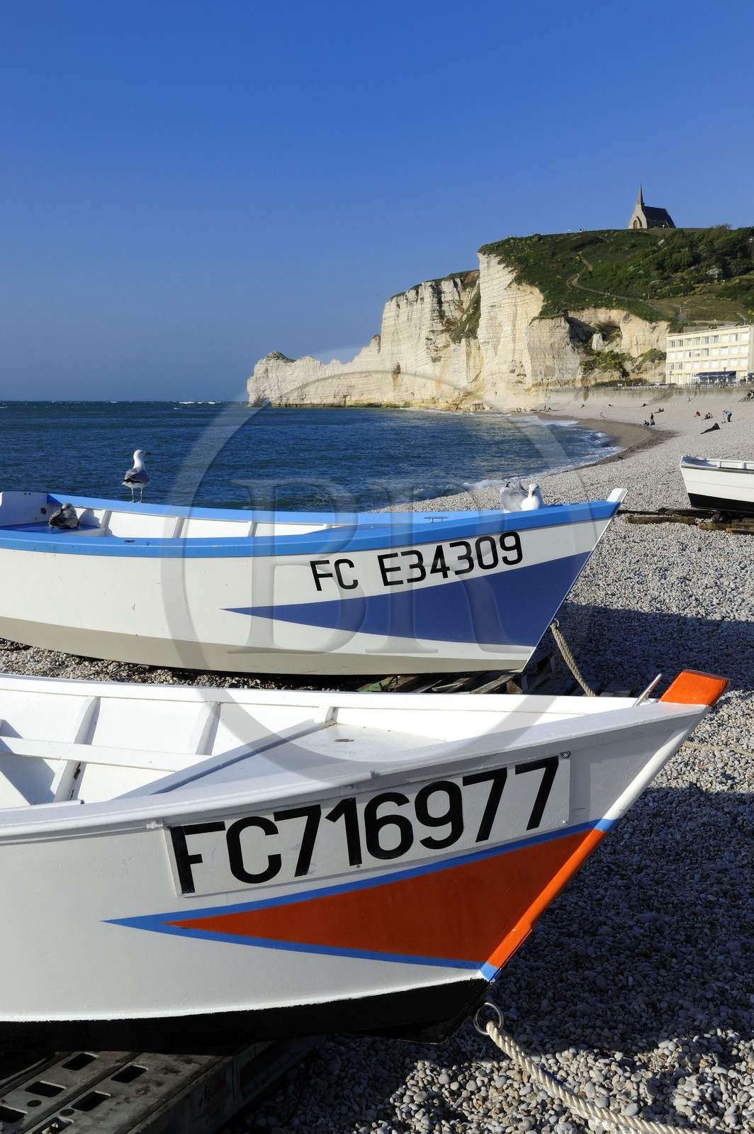 France, Seine-Maritime (76), Pays de Caux, Côte d'Albâtre, Etretat, la falaise d'Amont et l'église Notre-Dame-de-la-Garde depuis la plage de la ville avec les barques de pecheurs