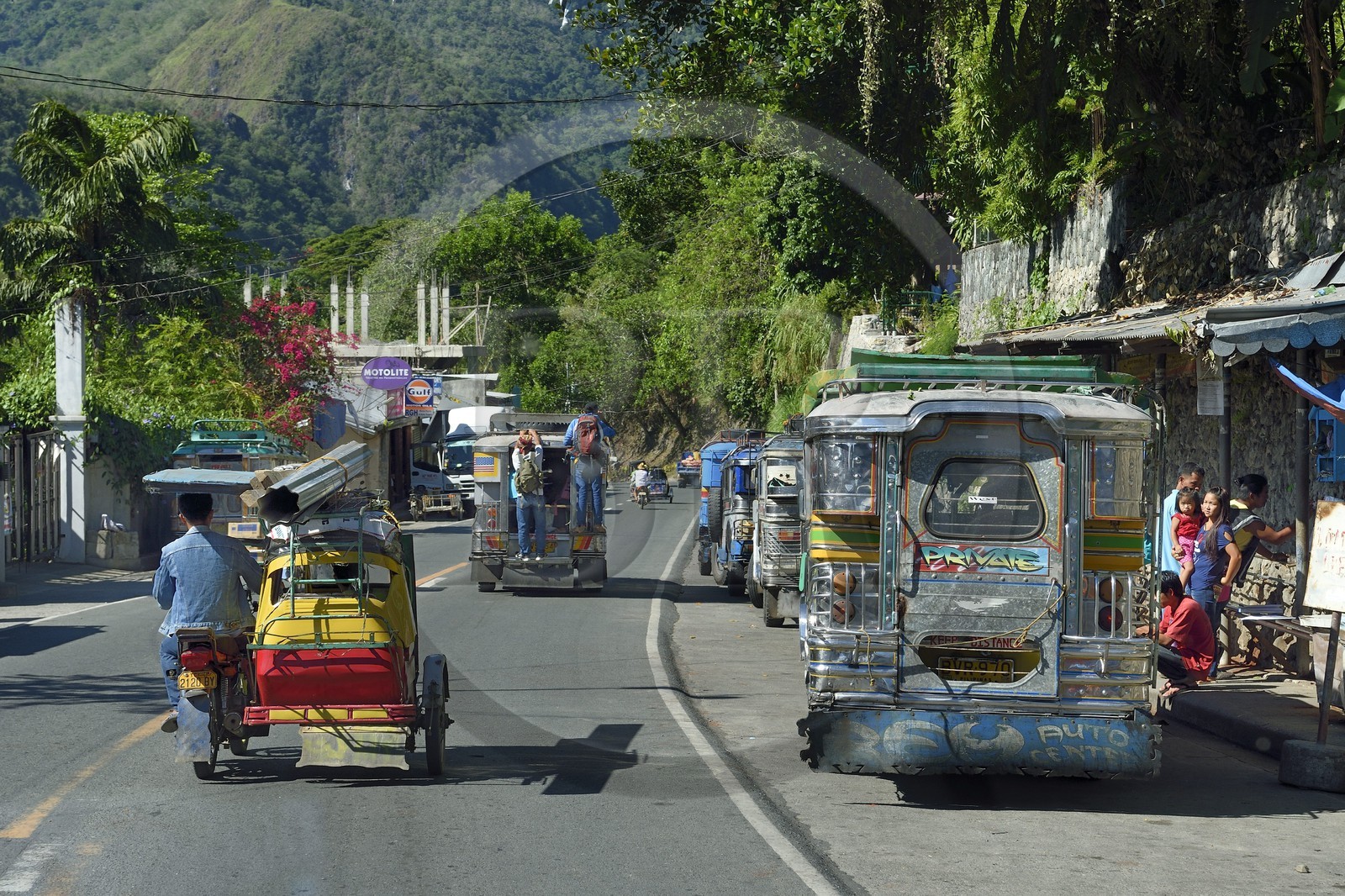 Philippines, Ifugao province, Poblacion city, jeepney (elongated jeep to transport passengers) and tricycle motorcycle taxi in main street