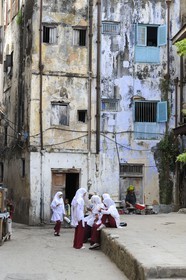 Tanzanie, archipel de Zanzibar, île de Unguja (Zanzibar), ville de Zanzibar, quartier Stone Town, classé Patrimoine Mondial de l' UNESCO, jeunes écolières devant des facades de maisons décrépies dans une ruelle de la vieille ville dans le quartier de Shangani