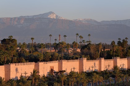 Morocco, High Atlas, Marrakech, Imperial city, Medina listed as World Heritage by UNESCO, the ramparts of the city and the Oukaïmeden summit in the snow-covered Atlas in the background at sunset
