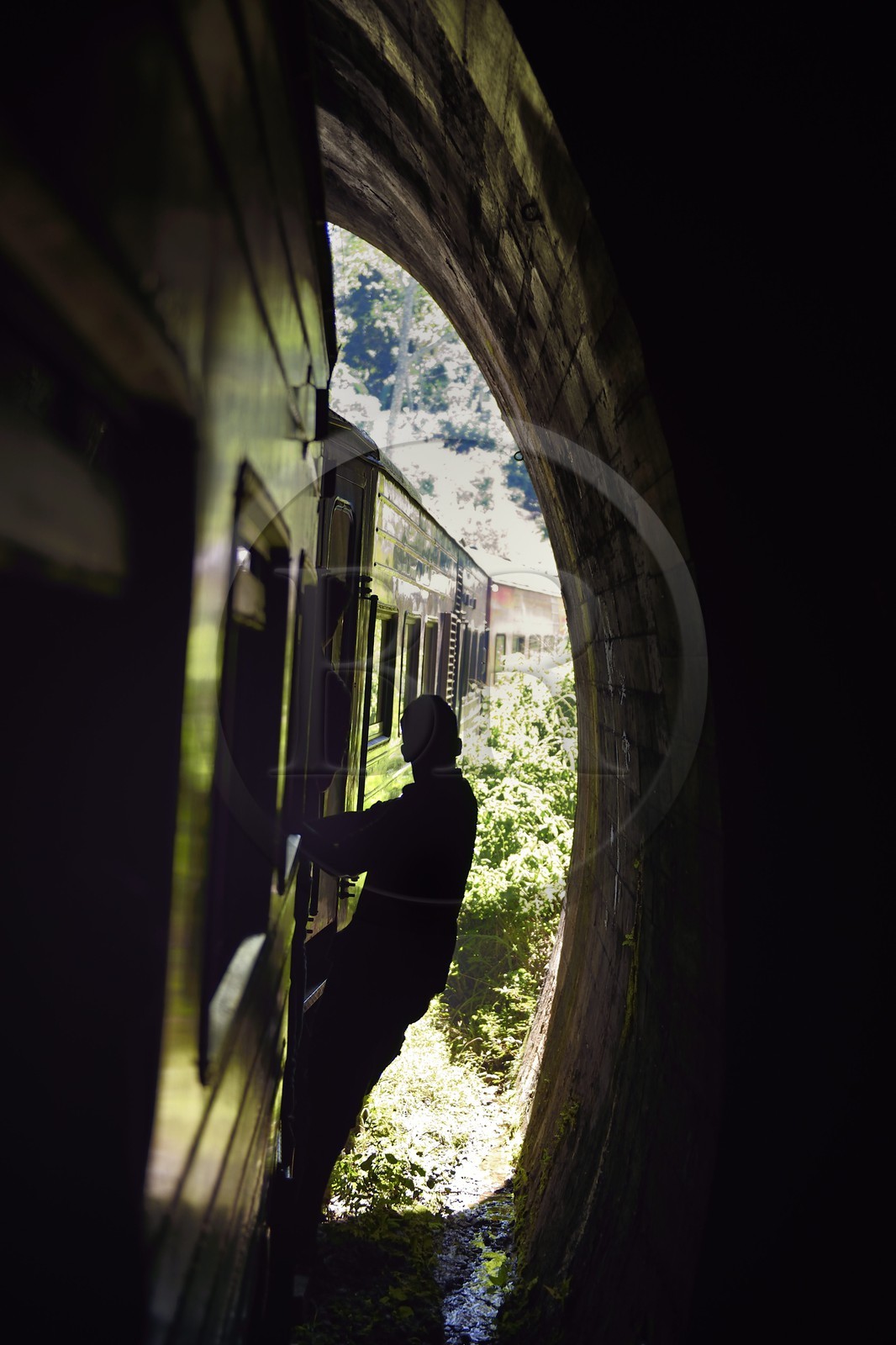 Sri Lanka, Province d'Uva, trajet en train dans la région montagneuse de la culture du thé entre Badulla et Ella, passager accrochés aux portières sous un tunnel