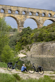 France, Gard (30), le Pont du Gard classé Patrimoine Mondial de l'UNESCO, Grand Site de France, cycliste prenant une pause devant le pont aqueduc romain qui enjambe le Gardon