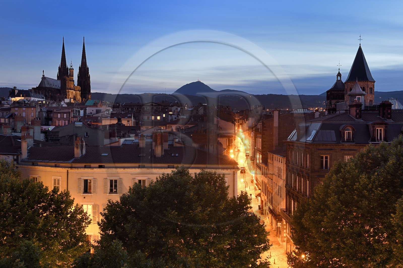 France, Puy de Dome, Clermont Ferrand, Rue du Port between Notre-Dame de l'Assomption cathedral on the left and Notre-Dame-du-Port basilica on the right, in the background the former volcano Puy de Dome