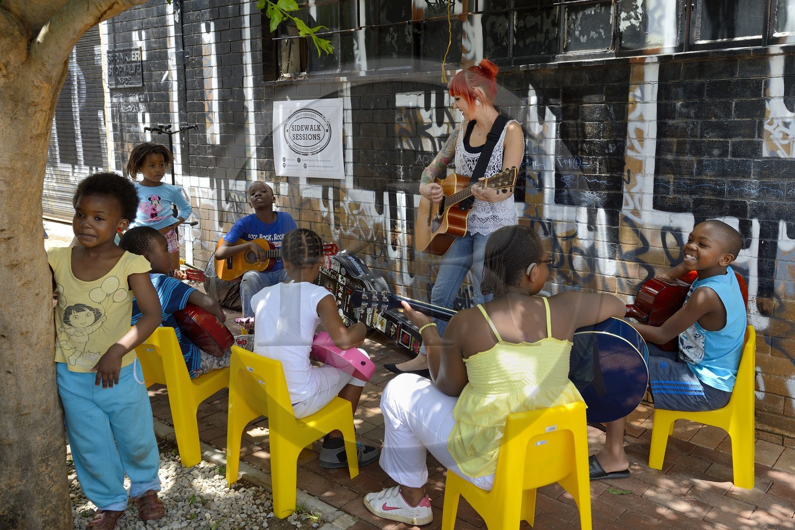Afrique du Sud, province de Gauteng, Johannesburg, CBD (Central Business District), quartier de Maboneng, Sidewalk Sessions dans Fox street, Kelly Grevler donne des cours de guitare gratuits pour de jeunes enfants dans la rue