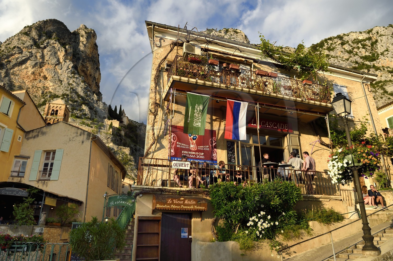 France, Alpes-de-Haute-Provence (04), Parc Naturel Régional du Verdon, Moustiers-Sainte-Marie, labellisé Les Plus Beaux Villages de France, café-restaurant dans le village le soir et l'Etoile de Moustier accrochée à une chaîne à plusieurs dizaines de mètres au-dessus du sol