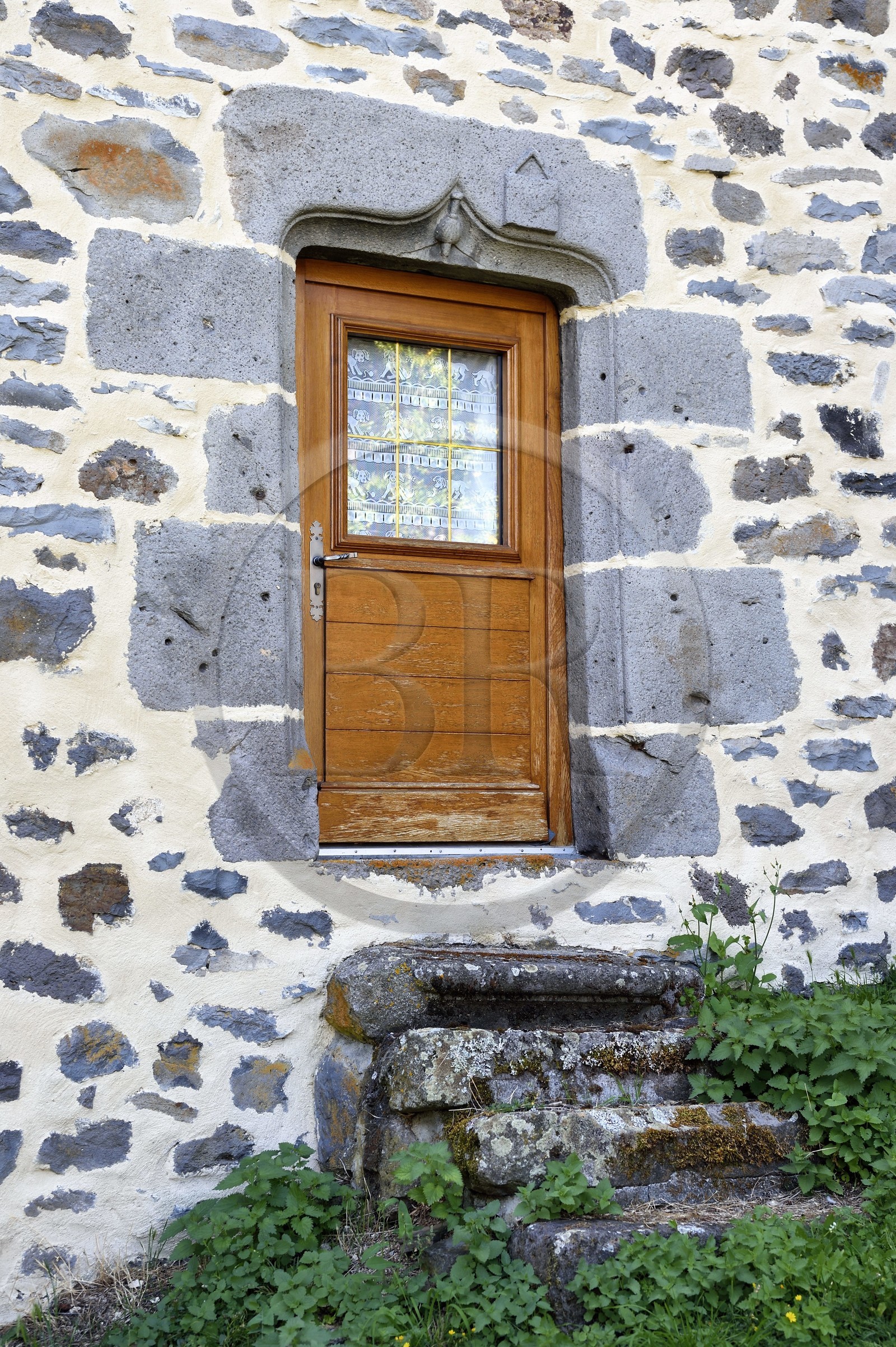 France, Cantal, Joursac, carved lintel of the house of a man who made the pilgrimage to Santiago de Compostela, we recognize the top of the bumblebee covered with a shell and the satchel which are symbols