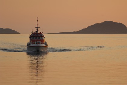 Norway, More Og Romsdal, boat entering Alesund's harbour at the midnight sun