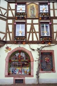 France, Haut-Rhin (68), Kaysersberg, maison à pans de bois de la boulangerie Loewert avec un tableau de la Vierge à l'Enfant sur la facade et des décorations de Noël