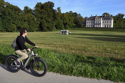 France, Seine-Maritime, Norman Seine River Meanders Regional Nature Park, Sahurs, chateau de Trémauville and cyclist on the veloroute of the Val de Seine