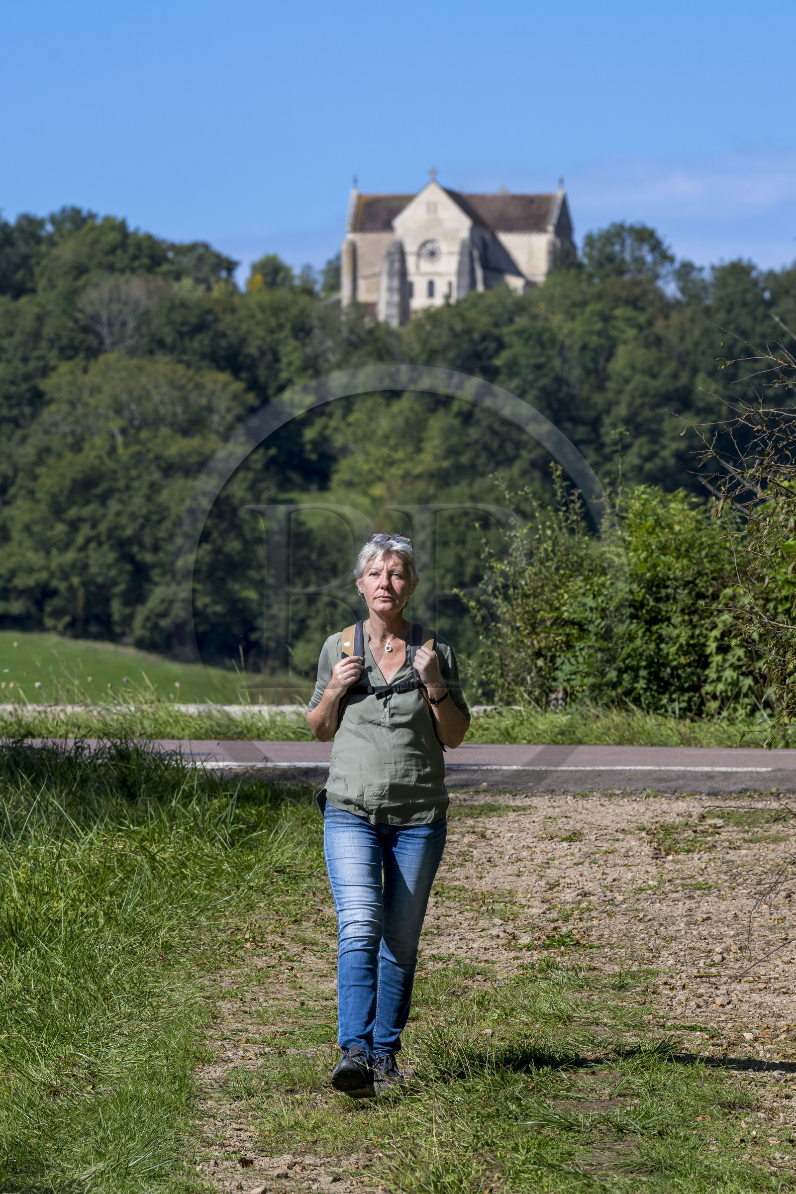 France, Yonne (89), Montréal (Bourgogne), randonneuse sur un chemin et la collégiale Notre-Dame en arrière plan