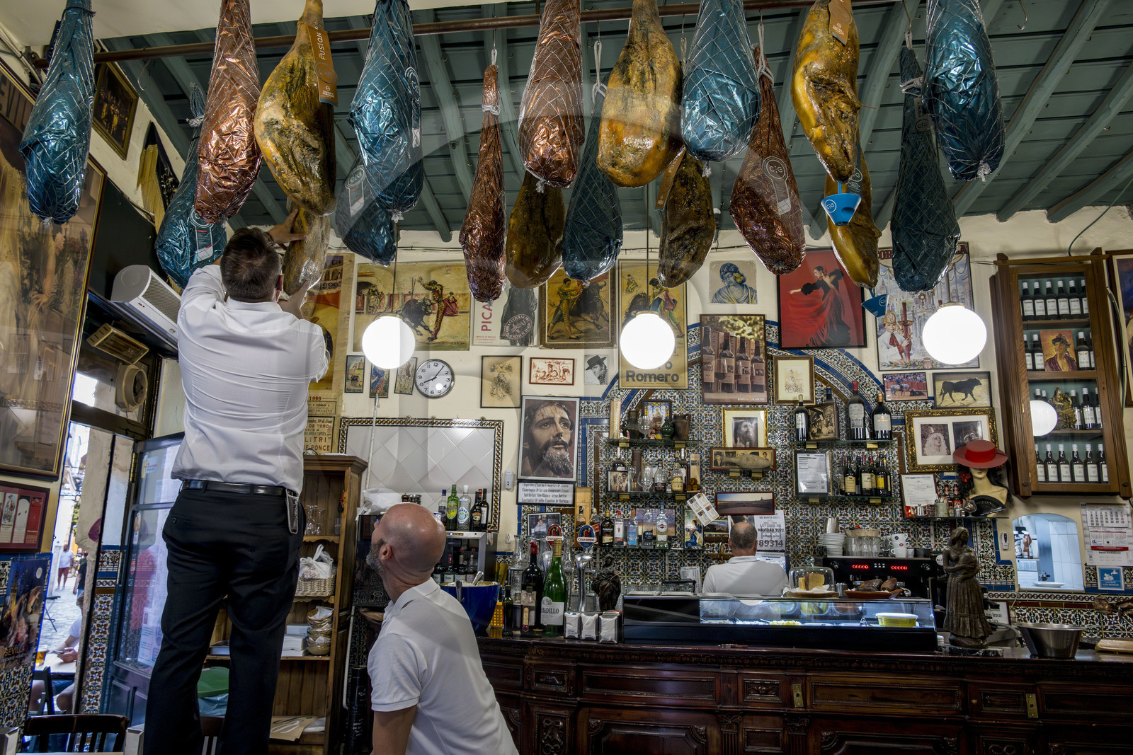 Espagne, Andalousie, Séville, bar à tapas Casa Placido, mise en place des jambons suspendus au plafond