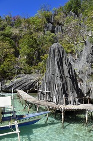 Philippines, Calamian Islands dans le nord de Palawan, Coron Island Natural Biotic Area, pirogue à balancier au pied des rochers de calcaire