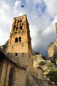 France, Alpes-de-Haute-Provence (04), Parc Naturel Régional du Verdon, Moustiers-Sainte-Marie, labellisé Les Plus Beaux Villages de France, l'église Notre-Dame-de-l'Assomption avec son clocher du XIIe siècle en tuff et l'Etoile de Moustier accrochée à une chaîne à plusieurs dizaines de mètres au-dessus du sol