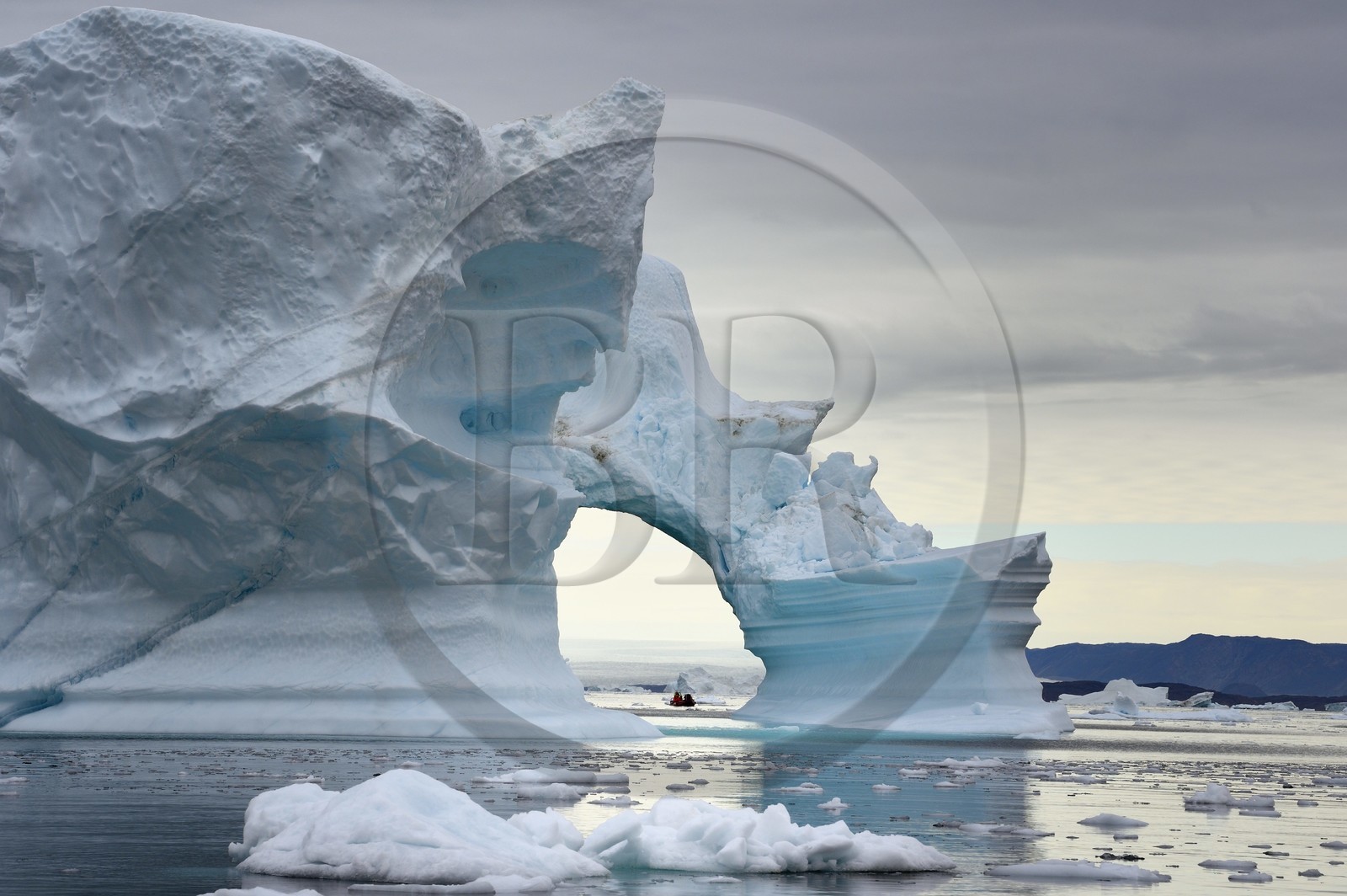 Groenland, cote Nord-Ouest, mer de Baffin, Inglefield Fjord vers Qaanaaq, iceberg formant un arche et un PolarCirkel boat (zodiac) d'exploration du bateau de croisière MS Fram de la compagnie Hurtigruten