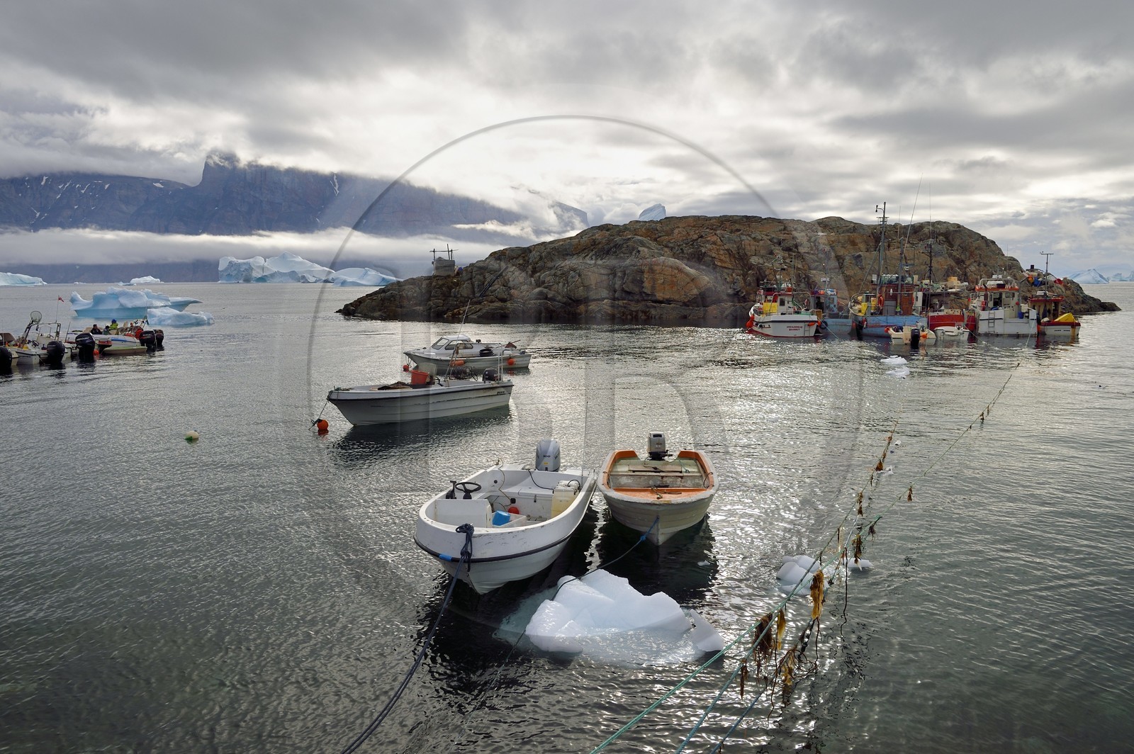Groenland, cote ouest, fjord de Uummannaq, bateaux pour la pêche et la chasse, icebergs à la sortie du port