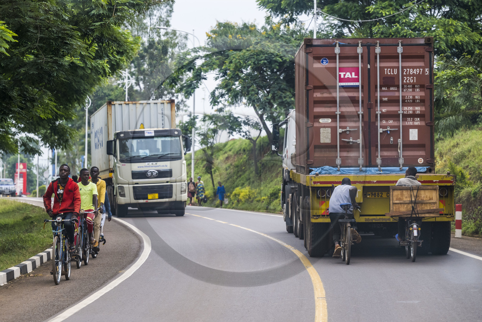 Rwanda, Province de l’Est, Rwamagana, cyclistes se tenant au cul des camions pour se faire tracter, les bicyclettes sont le principal moyen de transport local