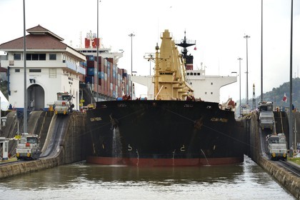 Panama, Panama Canal, Miraflores locks, mechanical mules or electric locomotives guiding a Panamax cargo between the lock walls