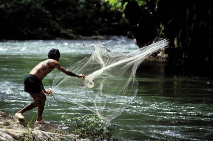 Malaisie, île de Bornéo, Sarawak, un Iban pêche au filet dans la rivière Engkari