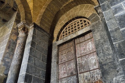 France, Haute-Loire (43), Le Puy-en-Velay, étape des chemins de Compostelle, porche de la cathédrale Notre-Dame-de-l'Annonciation du XIIe siècle classée Patrimoine Mondial de l'UNESCO, chapelle Saint Gilles latérale souterraine sous le porche, portes dites de cèdre en bois sculpté du XIIe siècle représentant des épisodes de la vie du Christ