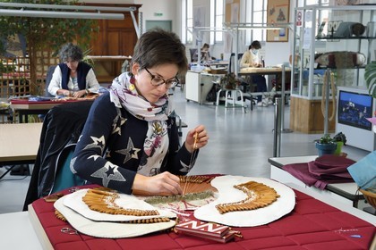 France, Haute Loire, Le Puy en Velay, National conservatory workshop of Puy lace (Atelier conservatoire national de la dentelle du Puy), bobbin lace on artists' creations commissioned by the national furniture department, the art technician (lacemaker) Carole Cubizolles on a traditional tile