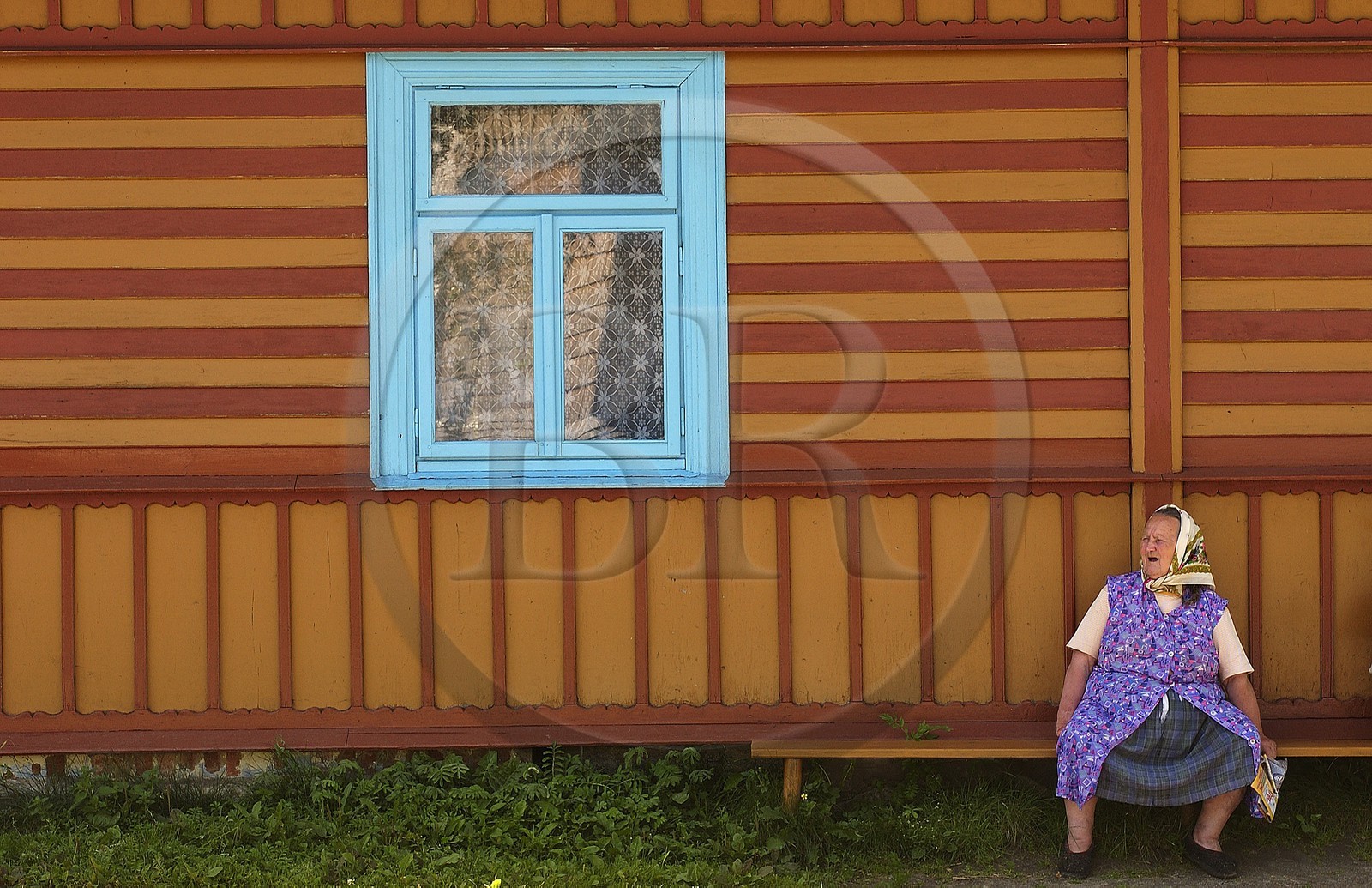 Pologne, Petite Pologne, Carpates, paysanne assis devant sa maison en bois peint dans le village de Debno