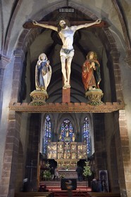 France, Haut-Rhin (68), Kaysersberg, église Sainte-Croix, Christ triomphant avec statues de la Vierge et de Saint-Jean du XVe siècle suspendus sous la voûte du transept et le choeur avec le retable de la Passion en bois de 1518 du sculpteur Jean Bongart en arrière plan