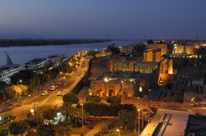 Egypt, Upper Egypt, Nile Valley, Luxor Temple at dusk, listed as World Heritage by UNESCO and the corniche road along the Nile