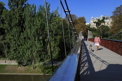 France, Paris (75), parc des Buttes Chaumont, la passerelle suspendue et les immeubles haussmanniens de la rue Manin