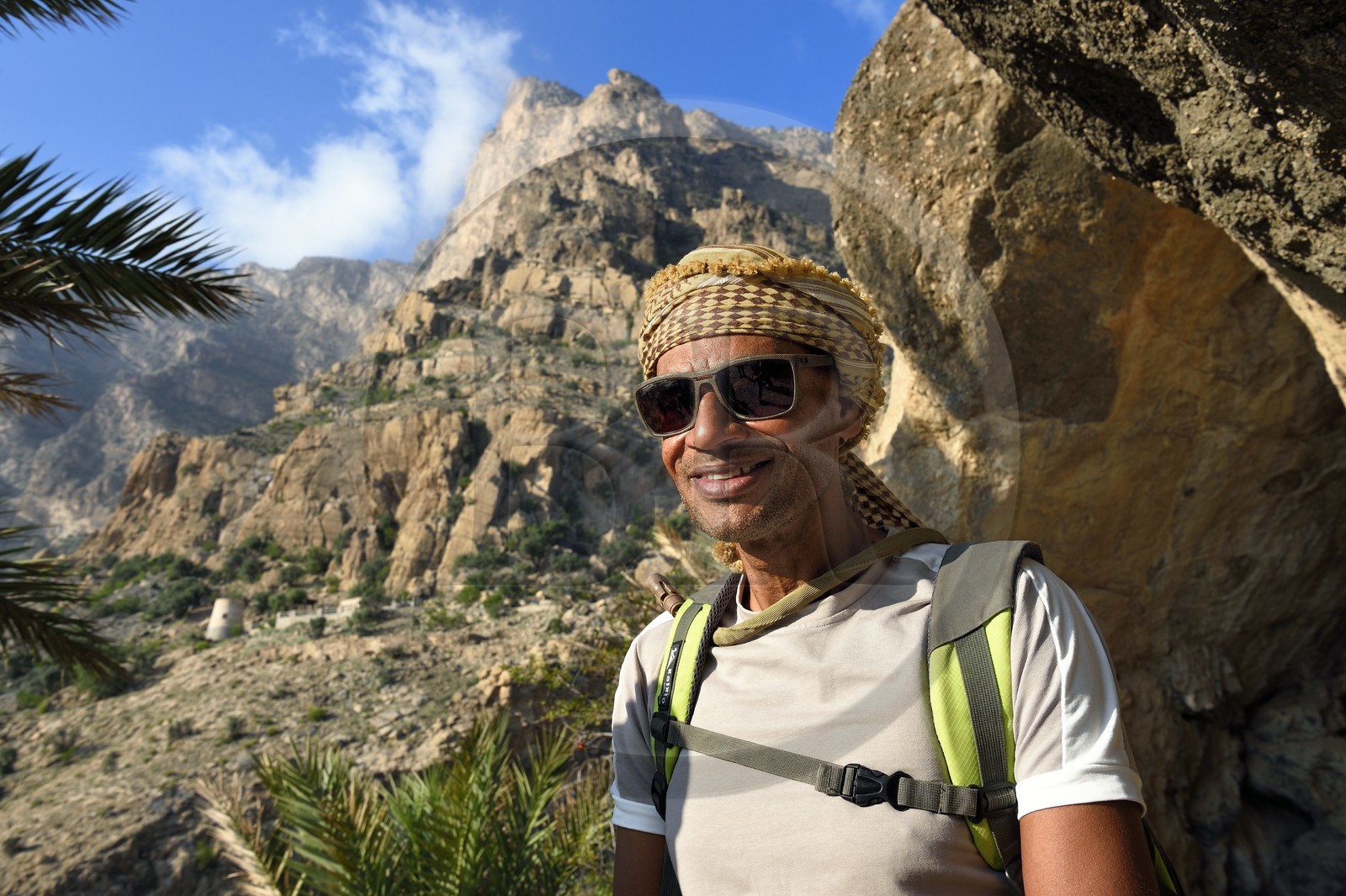 Sultanat d'Oman, Gouvernorat d'Al-Batina du Sud, Hajar occidental, Wadi Mistall, village de Wakan (Wukan), randonneur omanais sur le sentier de randonnée qui monte vers le sommet du Qarn Wukan (2501m) en arrière plan