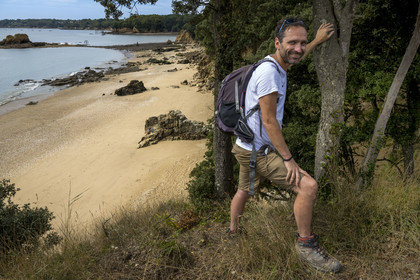 France, Loire-Atlantique (44), Estuaire de la Loire, Saint-Nazaire, plage de Kerloupiots, le randonneur Stéphane Le Naour sur le chemin des douaniers au démarrage du chemin de Grande Randonnée GR 34