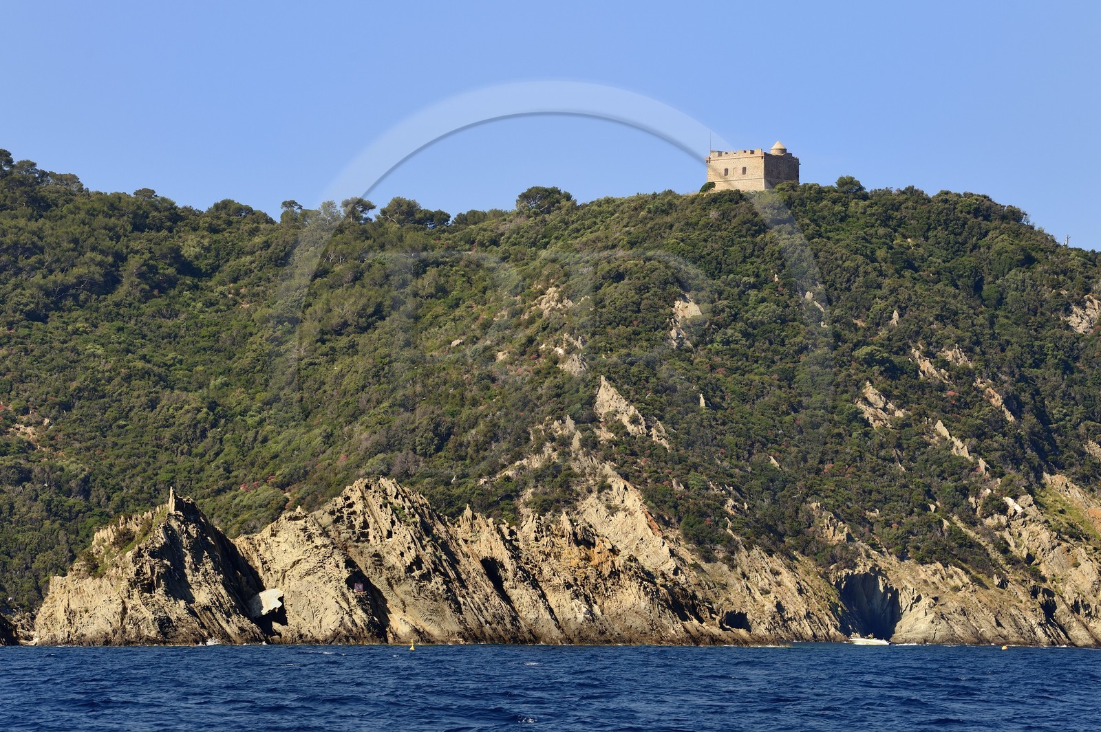France, Var (83), Iles d'Hyères, parc national de Port Cros, Ile de Port-Cros, bateau passant sous le Fort de L'Estissac sur la côte nord à la pointe du Miladou et le rocher du Rascas au premier plan
