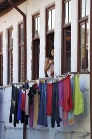Portugal, Minho region, Guimaraes, girl at a window in a small alley below the square Largo do Toural