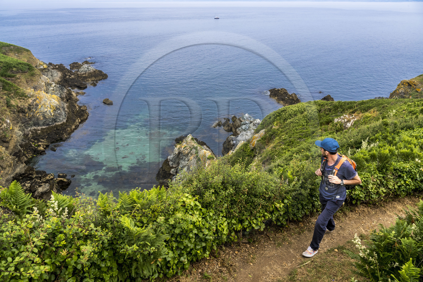 France, Morbihan, Groix Island, the Pointe de Pen-Men nature reserve, hiker on the coastal path