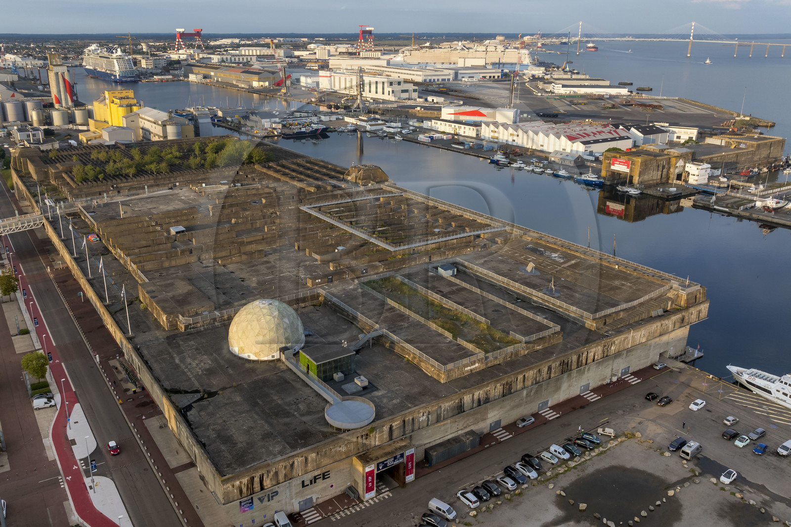 France, Loire Atlantique, Saint Nazaire, the former German submarine bases built during the last world war border the water basin of the port of Saint-Nazaire, in the background on the left the Penhoët basin and on the right the Saint-Nazaire bridge (aerial view)