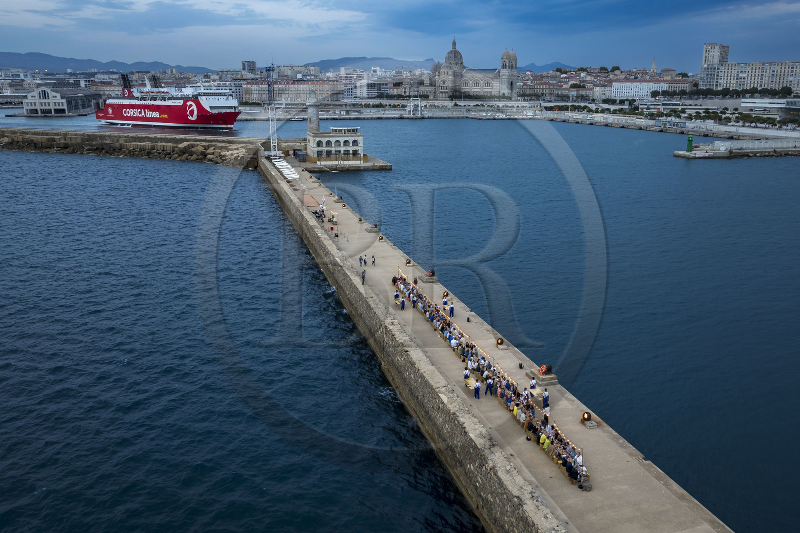France, Bouches-du-Rhône (13), Marseille, Zone Euroméditerranée, grand port maritime de Marseille (GPMM), la digue du large, convives attablés à une grand table de banquet dressée par le chef Emmanuel Perrodin dans le cadre des Diners Insolites, un ferry de Corsica Linea quitte le port (vue aérienne)