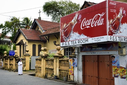 Sri Lanka, Province du Sud, Fort de Galle, classé Patrimoine Mondial de l'UNESCO, nonne devant le Apostolic Carmel Sisters dans lighthouse street et panneau publicitaire pour Coca-Cola