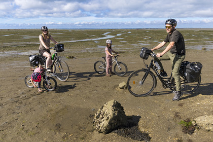 France, Vendée (85), île de Noirmoutier, Barbatre, famille de cyclistes sur l'estran en bordure du passage du Gois, chaussée submersible qui relie l'île au continent à marrée basse