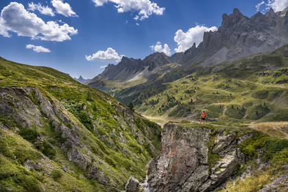 France, Hautes Alpes (05), le Briançonnais, Névache, randonneuse avec ses chiens dans la haute vallée de la Clarée, le massif des Cerces en arrière-plan
