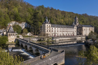 France, Dordogne, Brantome, cyclists traveling along the Flow Vélo cycle route crossing the Pont Coude (angled bridge) over Dronne River, Saint Pierre benedictine abbey in the background (aerial view)