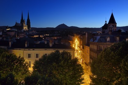 France, Puy de Dome, Clermont Ferrand, Rue du Port between Notre-Dame de l'Assomption cathedral on the left and Notre-Dame-du-Port basilica on the right, in the background the former volcano Puy de Dome