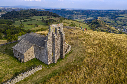 France, Cantal, Parc Naturel Régional des Volcans d'Auvergne (regional nature park of Auvergne volcanoes), Chastel-sur-Murat, 12th century perched on a promontory Saint Antoine (Saint Anthony) Chapel, hickers on the Way of St. James to Santiago de Compostela by Via Arverna (aerial view)