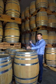 France, Ile de la Reunion, Saint Pierre, domaine de la distillerie Isautier, vieillissement des rhums vieux dans les chais entre 6 et 14 mois en futs neufs puis plusieurs années ensuite par lot en futs roux, Cyril Isautier directeur de la branche rhums et punchs du groupe Isautier fait un prélèvement à la pipette pour une dégustation