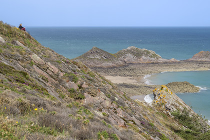 France, Cotes d'Armor, Grand Site de France Cap d'Erquy – Cap Frehel, Erquy, hiker looking at Lourtouais (naturist) beach to the east of Cap d'Erquy
