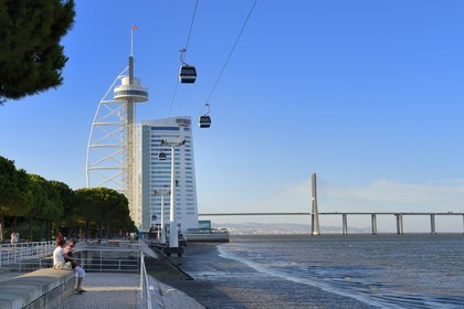 Portugal, Lisbon, Parque das Nações (Nations' Park) built for the Universal Expo 98 World Exhibition, Vasco de Gama Tower hosting the hotel Myriad by SANA Hotels and cable cars running along the Tagus river, in the background the Vasco da Gama Bridge