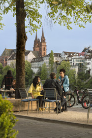 Suisse, Bâle, les quais du quartier du Petit Bâle sur la rive droite du Rhin et la cathédrale protestante Notre-Dame de Bâle (Munster) en arrière plan, terrasses de restaurants et cafés s'animent à la tombée du soir