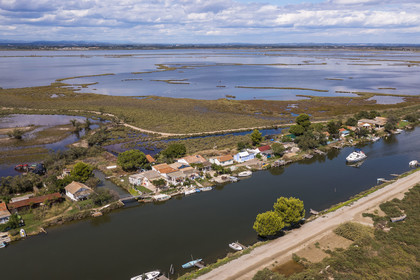 France, Hérault (34), La Grande-Motte, lieu dit des Cabanes du Roc, anciennes cabanes de pécheurs en bordure du canal du Rhône à Sète, l'étang de l'Or en arrière plan (vue aérienne)
