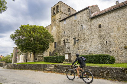 France, Aveyron (12), parc naturel régional des Grands Causses, cyclistes effectuant l'itinéraire cyclo touristique Brebis'Cyclette en Pays de Roquefort, le fort cistercien de Saint-Jean-d’Alcas, église  Saint-Jean de l'ancienne abbaye de Nonenque