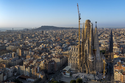 Espagne, Catalogne, Barcelone, quartier de l'Eixample, basilique de la Sagrada Familia de l'architecte du modernisme catalan Antoni Gaudi classée Patrimoine Mondial de l'UNESCO, façade de la Nativité, le port et la colline de Montjuic en arrière plan