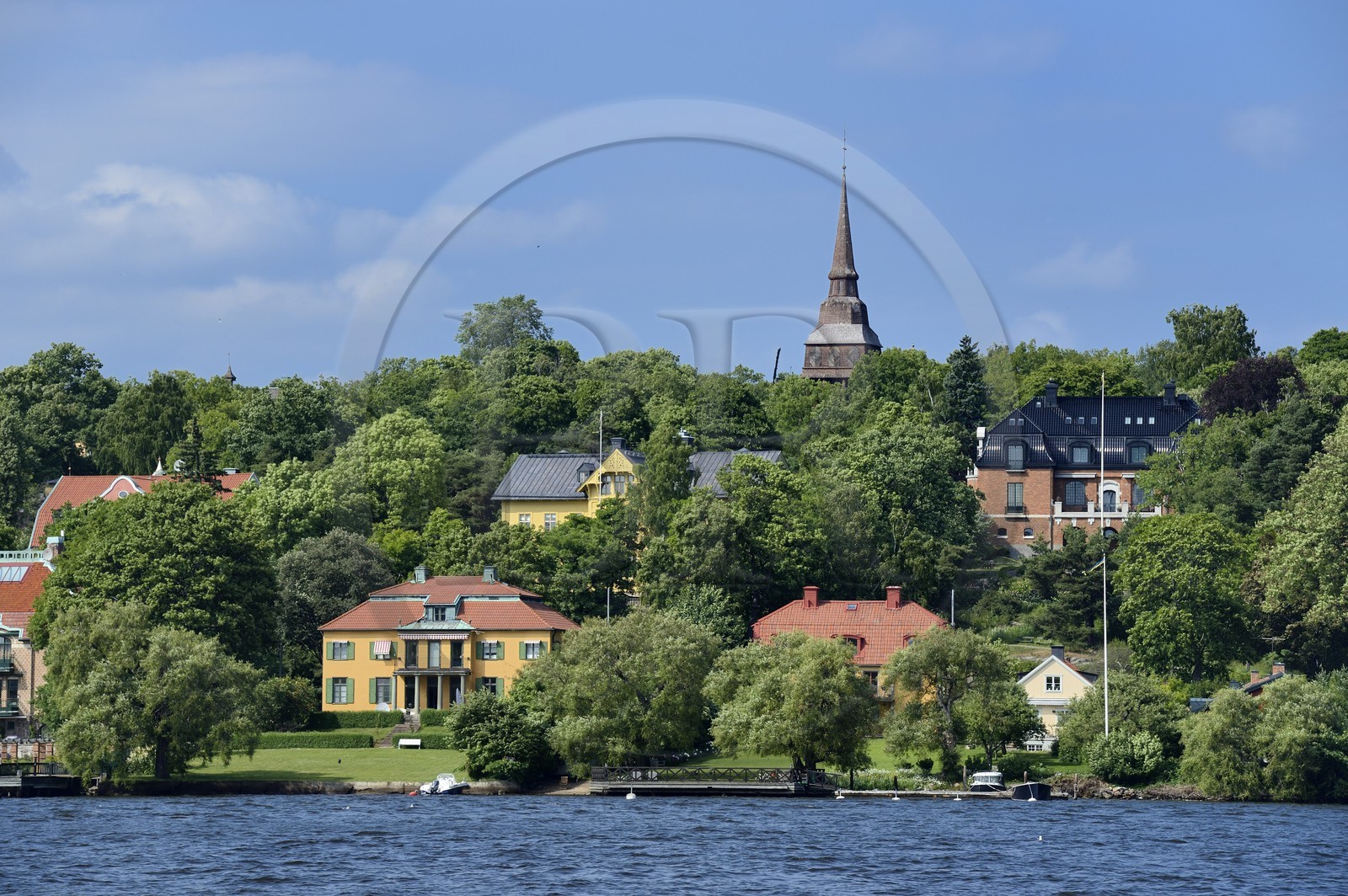 Sweden, Stockholm, Djurgarden, seaside villas and the Hallestad belfry in the open air museum Skansen in the background