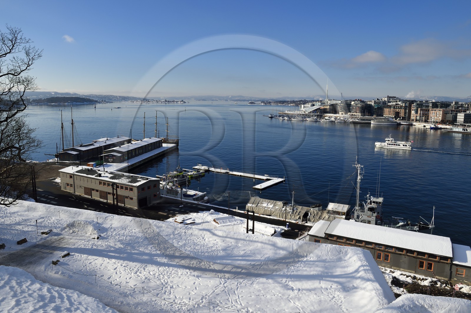 Norway, Oslo, the fjord, the harbor and the Pipervika docks seen from the Akershus hill under the snow, the Aker Brygge district in the background right